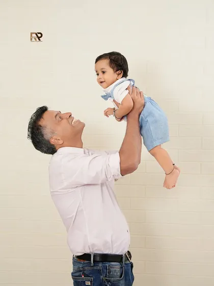 The special bond between a father and his child. This candid shot captures a moment of pure fun and connection, set against a clean and simple background.