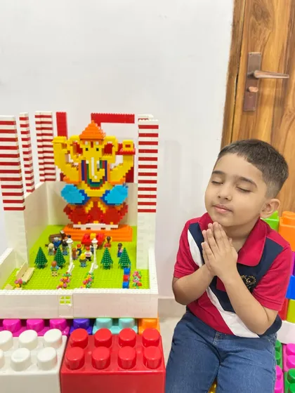 A young boy offers a prayer to a beautifully constructed LEGO Ganesha idol placed in a miniature pandal. This moment captures the wonderful blend of devotion, play, and creativity that our workshops inspire.