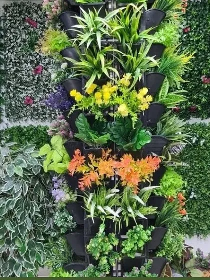 A display showing different options for vertical garden panels. This includes modular planters for real plants and various styles of artificial green wall tiles to suit different tastes and requirements.