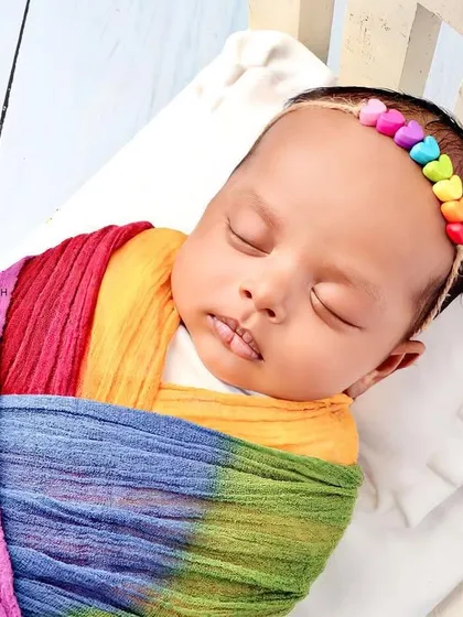 An angled shot of the baby sleeping in the rainbow wrap.
