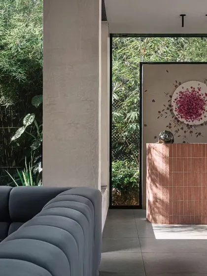 The entertainment room features a comfortable, large sofa and a bar made of pink bricks. The custom artwork behind the bar adds a whimsical touch to this relaxed, social space.