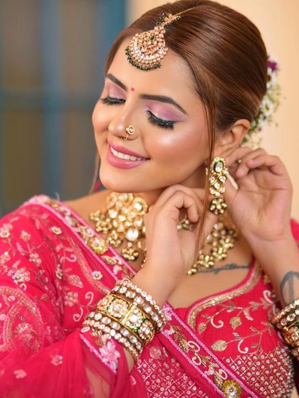 A close-up showing the intricate details of the jewellery paired with a pink lehenga. The floral hair accessories add a fresh touch to this rental look.