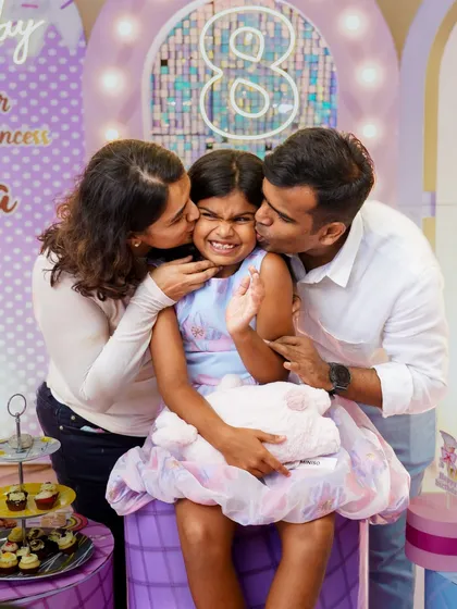 A squeeze from mom and dad is the best. Capturing these moments of pure love and affection is at the heart of what we do. This candid family portrait from a princess themed birthday party is a perfect example of the warmth we aim to preserve.