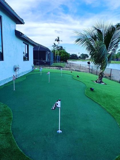 This backyard putting green was designed to fit the long space next to the house, overlooking the water. It features multiple holes for varied putting practice.