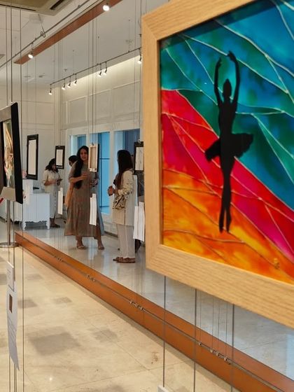 A view of the 'Finding Solace' exhibition, showing the elegant setup of our gallery and guests admiring the colorful artworks.