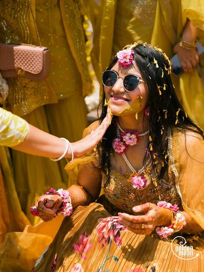 A cool bride enjoying her Haldi ceremony. We love capturing the fun and personal touches that make your wedding unique.