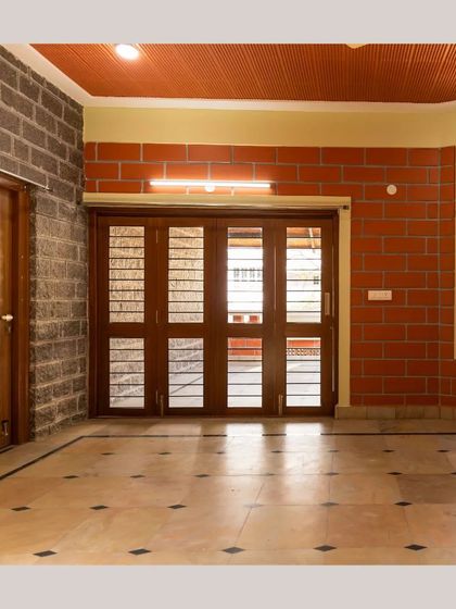 An interior shot showing the contrast between a stone wall and a brick wall, connected by a large wooden door frame.