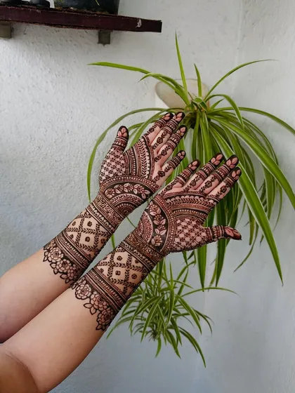 This is a beautiful example of symmetrical design work, where both hands mirror each other with elaborate floral and geometric patterns for a harmonious finish.