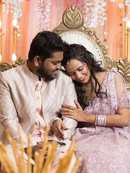 A tender moment on the stage, with the bride-to-be resting her head on her partner's shoulder.