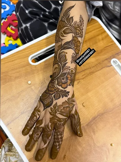 This design features a beautiful trail of flowers and leaves that winds its way up the arm, starting from the hand. It's a graceful and sophisticated choice for any guest.