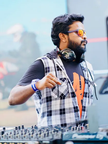 Focused and in the zone during an outdoor festival set. Using my Pioneer decks, I'm constantly mixing and matching tracks to create a unique vibe for each event, whether it's a daytime party or a late-night celebration.