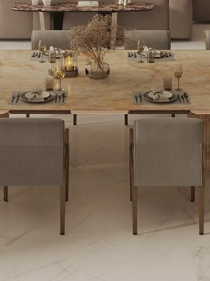 A close-up of the elegant dining table setup in a luxury penthouse. The fluted base of the table and the plush chairs create a refined setting for formal entertaining.