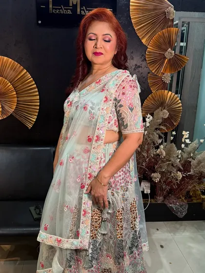 The same beautiful mom in a different outfit, a floral lehenga. The makeup is soft and complements the pastel colors of her attire.