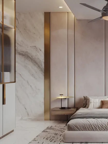 A detailed view of the bedside, showing the interplay of textures between the upholstered wall panels, the marble feature wall, and the brushed gold trim.