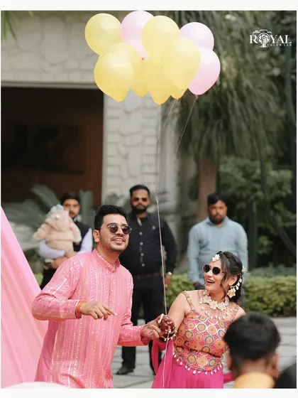 A playful moment from the Haldi ceremony, with the couple holding a bunch of balloons.