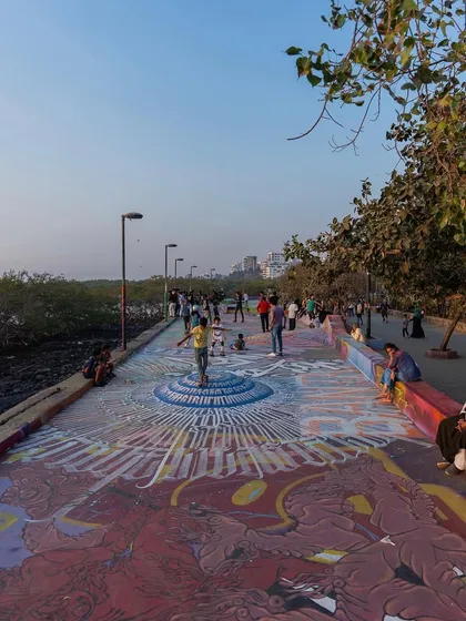 A wide shot of the Carter Road promenade in Mumbai, showing how the skatepark mural becomes a piece of public art for the whole community to enjoy.