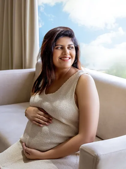 A solo portrait of the mom-to-be, relaxed and glowing on her own couch. This is what capturing authentic moments looks like.