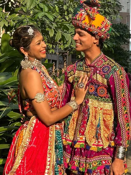 The perfect match for Navratri. This couple looks radiant in their coordinated red and multi-color outfits, showing how my sets bring people together in celebration.