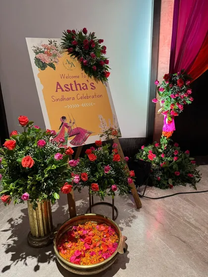 Personal touches make an event special. I designed this custom welcome sign for the 'Sindhara' celebration, surrounded by fresh flowers that matched the event's color scheme. A bowl of petals was kept for guests to shower their blessings.