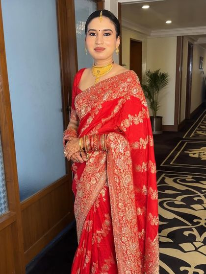 A vision of glam and grace for Damini's wedding day. Dressed in a traditional red saree, her makeup was kept minimal and elegant with a focus on a flawless base and a soft, warm eyeshadow.