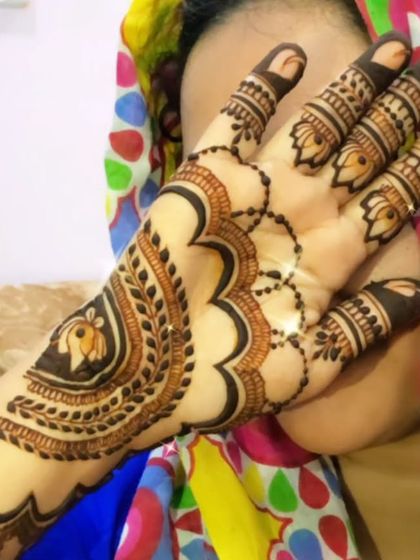 A striking back-hand design in a bold Arabic style. The pattern features a large central motif with heavy shading and delicate details, creating a powerful and artistic statement.