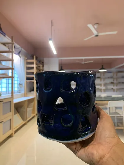 A hand-built piece with intricate cut-outs, glazed in a deep, glossy blue. This was made by one of our youngest students, just 11 years old!