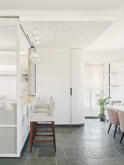 A wider view of the space featuring Kota stone flooring. The design balances the rustic feel of the stone with clean, modern lines and bright, airy whites.