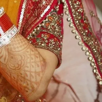 A close-up of the bride's chooda (bangles) and the embroidery on her blouse. These details are an essential part of the wedding story.