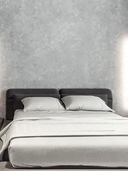 Vertical sconces combined with recessed ceiling lights create a layered lighting scheme in this minimalist bedroom, offering both ambient and accent illumination.