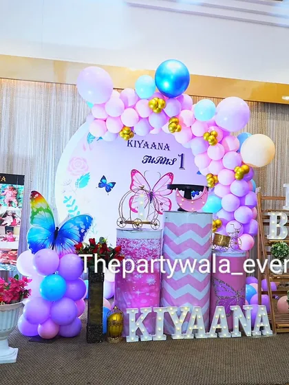 Another angle of the butterfly theme, showing the full stage and the light-up name sign. The mix of pink, purple, and blue balloons is very eye-catching.