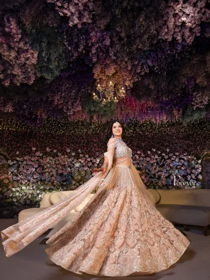 My goal is to create a fairytale setting where the bride is the star. Here, the bride twirls amidst a canopy of cascading purple and pink flowers, a truly magical moment where the decor becomes an extension of her joy and elegance.