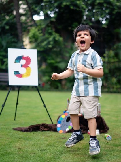 A jump for joy! The pure energy and excitement of being a toddler, perfectly captured during his outdoor painter-themed shoot.