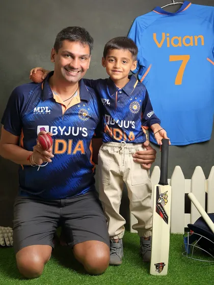 A father and son share their love for cricket. This is a wonderful way to bond and create a personalized photoshoot based on a family's shared passion.