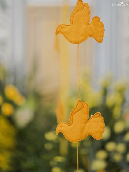 A small, thoughtful detail of handcrafted yellow birds hanging as part of the decor.