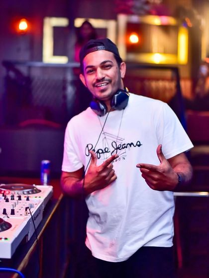 A candid moment behind the decks, ready for the night ahead. This is the calm before the storm of a high energy DJ set.