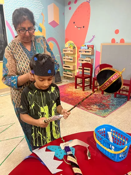 An instructor helps a young actor with his costume during the Ramleela preparations. We make sure every child feels ready and confident for their part.