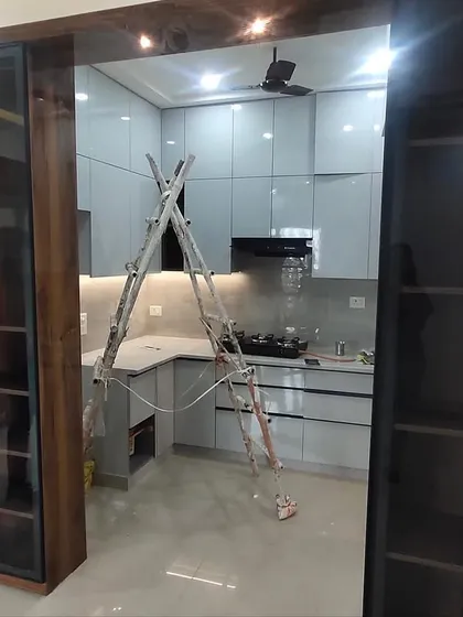 A view from the living area into the nearly finished kitchen, showing how the wooden-framed glass partition creates an open yet separate feel.