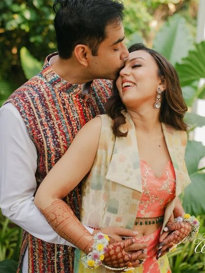 Sweet, candid moments from a Haldi function. A groom's gentle kiss on his bride's forehead shows the love and tenderness that shine through even during the most playful ceremonies.