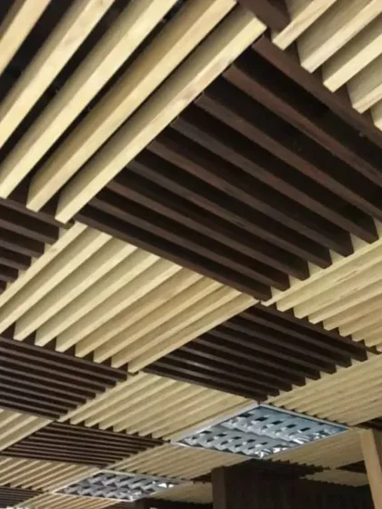 A close-up view of a two-tone rafter ceiling design. The alternating light and dark wood-look rafters create a visually interesting checkerboard pattern that adds a unique custom touch to the pergola.