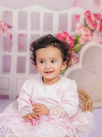 A bright, happy smile from this little girl during her pink-themed sitter session. Her joy is absolutely contagious.