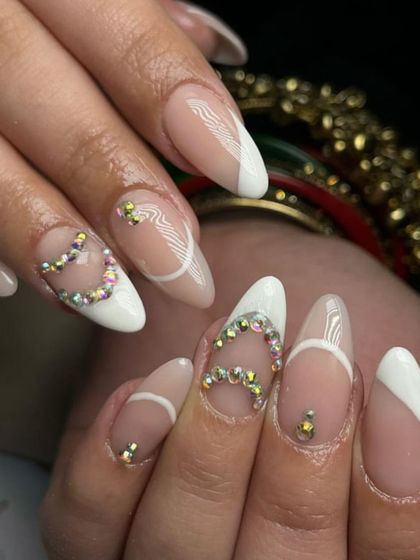 A fun and flirty design with a slanted white French tip and sparkling rhinestone hearts.