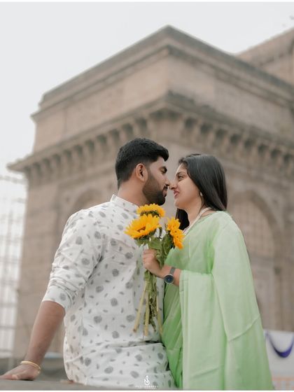 A creative and sweet pose using the sunflowers to frame their faces.