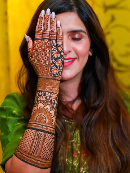 A side view of a detailed bridal mehndi, highlighting the intricate patterns that wrap around the arm.