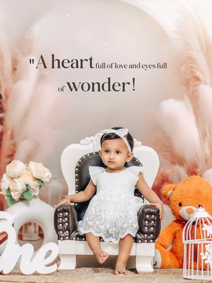 A serene and beautiful first birthday portrait. The all-white outfit and backdrop with pampas grass create a dreamy and angelic look for this studio session.