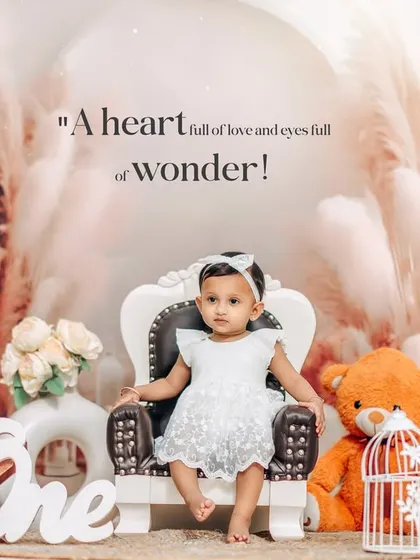 A serene and beautiful first birthday portrait. The all-white outfit and backdrop with pampas grass create a dreamy and angelic look for this studio session.