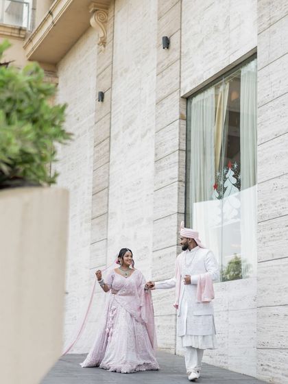 A stylish portrait of the couple walking together outside their modern wedding venue.