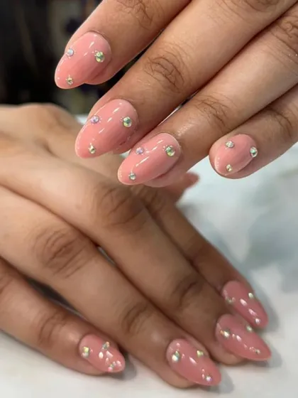 A simple yet elegant design. We used a soft, peachy-pink gel polish and adorned each nail with a scattering of small, iridescent rhinestones for a subtle sparkle.