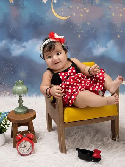 A classic character brought to life. This little one is all smiles, dressed up in a Minnie Mouse-inspired outfit against our dreamy night sky backdrop.