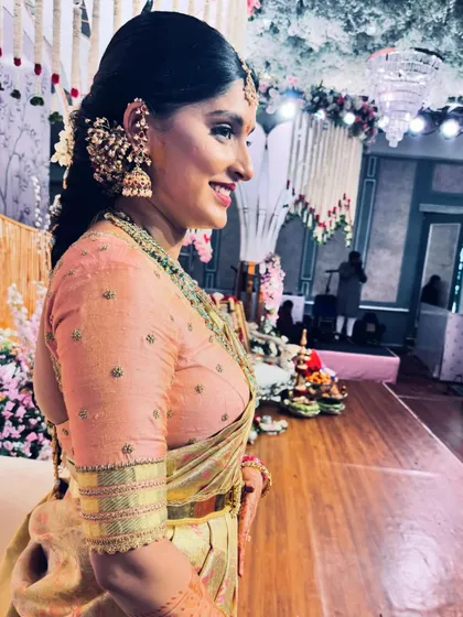 A side profile of Akanksha at her engagement, her smile lighting up the photo. The delicate embroidery on her blouse sleeve is visible.