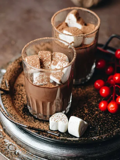 Hot chocolate and marshmallows, the best part of winter. This shot uses a vintage silver tray and rustic styling to create a cozy, festive atmosphere.